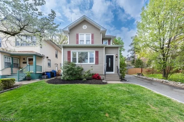 a front view of a house with a yard and green space