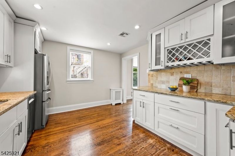166 Valley Road Montclair, NJ 07042 - Photo 22 of 37 a kitchen with granite countertop white cabinets and wooden floor
