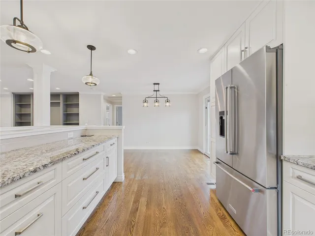 a kitchen with granite countertop a refrigerator and a sink