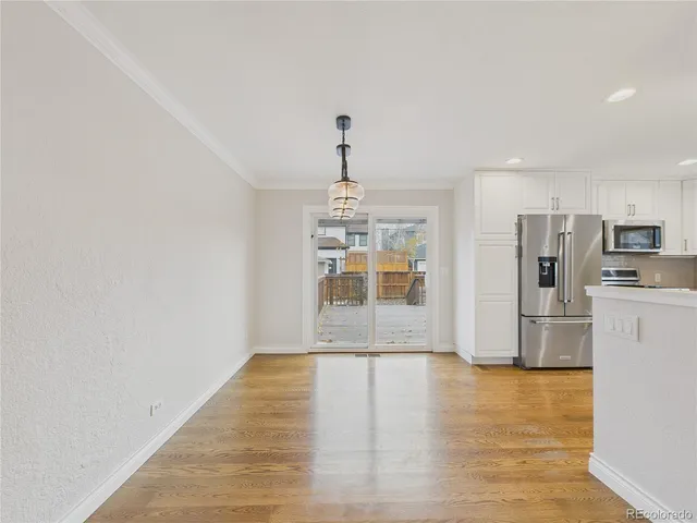 a view of a kitchen with refrigerator and window