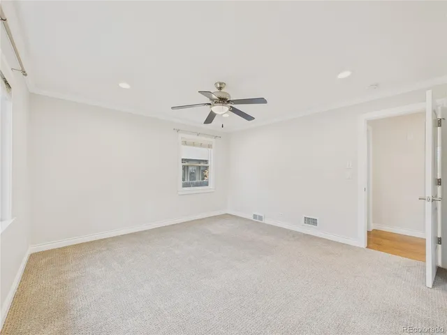 an empty room with a ceiling fan and a window