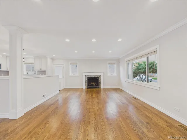 a view of an empty room with a window and fireplace