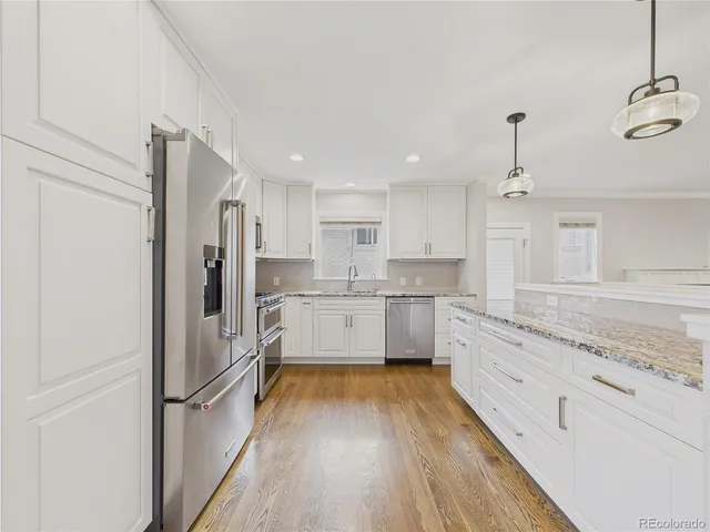 a kitchen with stainless steel appliances granite countertop a refrigerator and a stove top oven