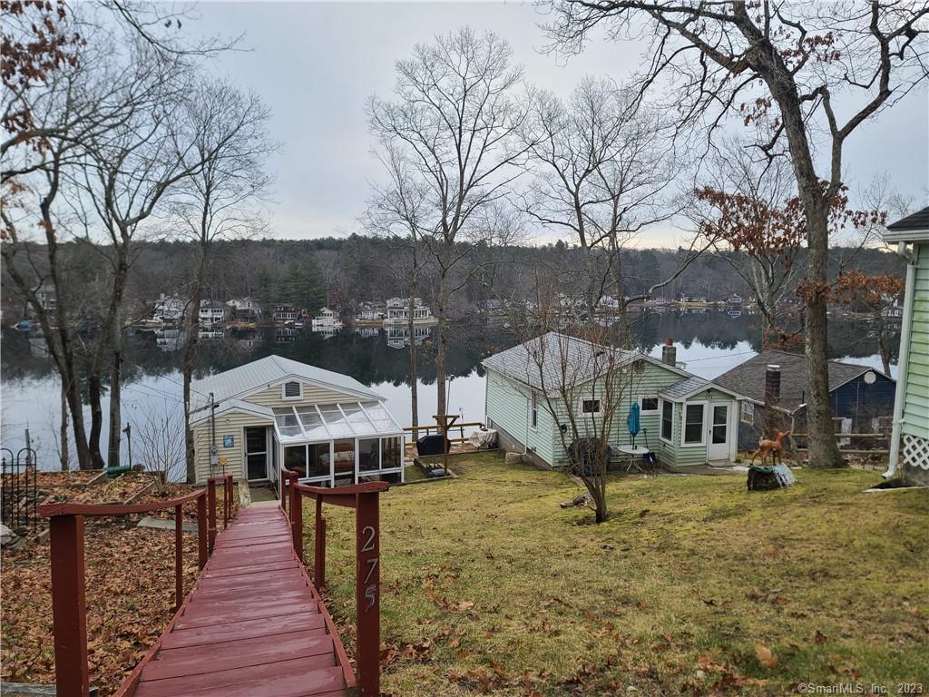 a front view of a house with a yard and large trees