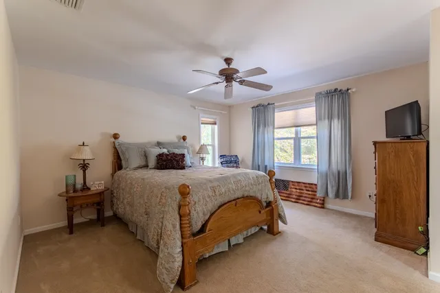 a spacious bedroom with a bed and a chandelier