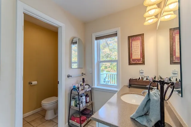 a bathroom with a granite countertop toilet sink and mirror