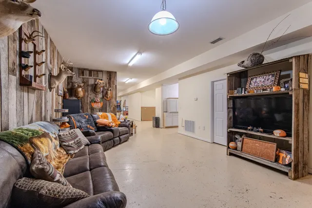 a living room with furniture a flat screen tv and a window