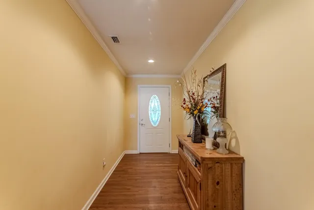 a view of a hallway to a room with wooden floor