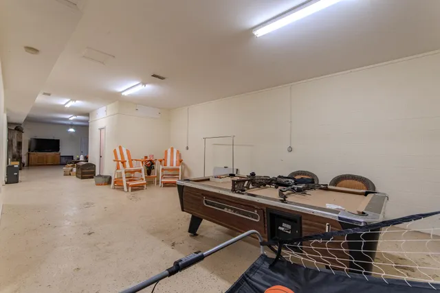 a gym room with furniture a table and a flat screen tv
