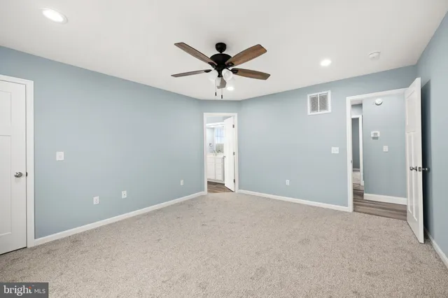 a view of an empty room and a ceiling fan