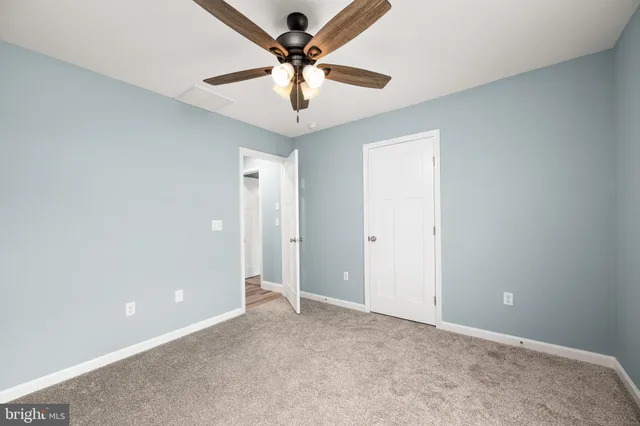 an empty room with a fan and a fan