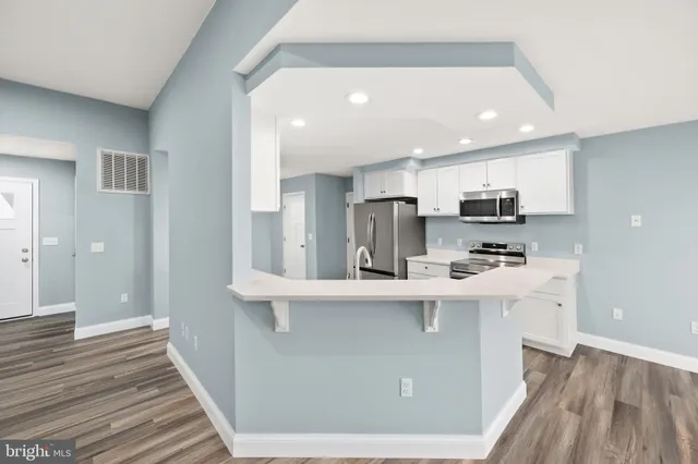 a kitchen with stainless steel appliances a sink stove refrigerator and cabinets