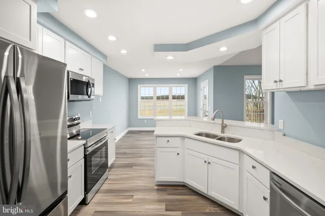 a kitchen with stainless steel appliances granite countertop a refrigerator sink and stove