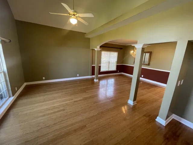 a view of an empty room with wooden floor