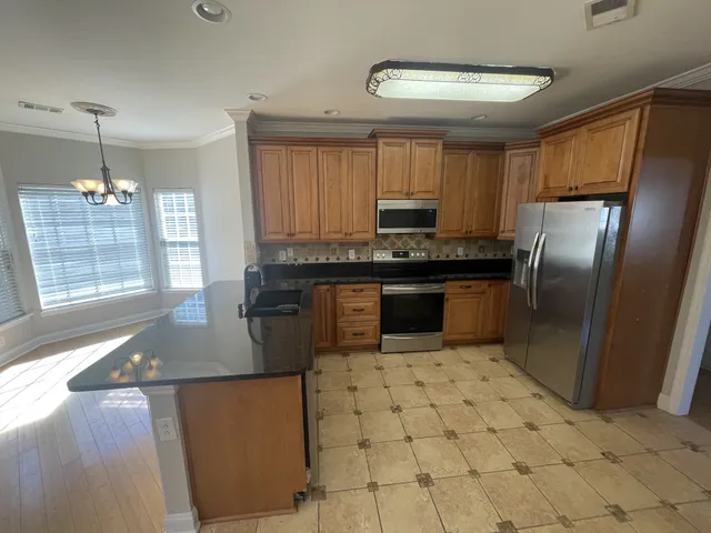 a kitchen with stainless steel appliances granite countertop a refrigerator a sink a stove a microwave and island