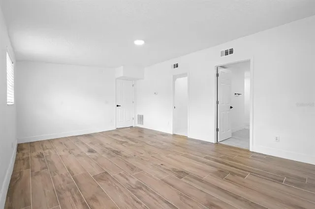 a view of empty room with wooden floor