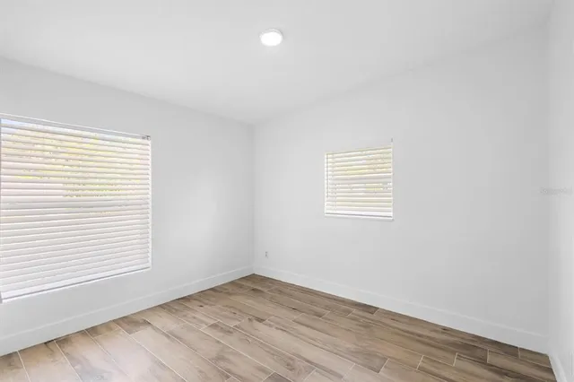 a view of empty room with wooden floor