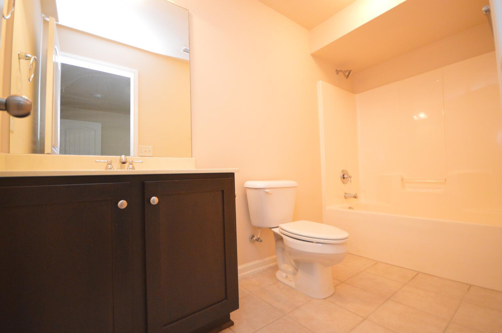 2053 Weston Green Loop Cary, NC 27513 - Photo 30 of 35 a bathroom with a sink a toilet and mirror