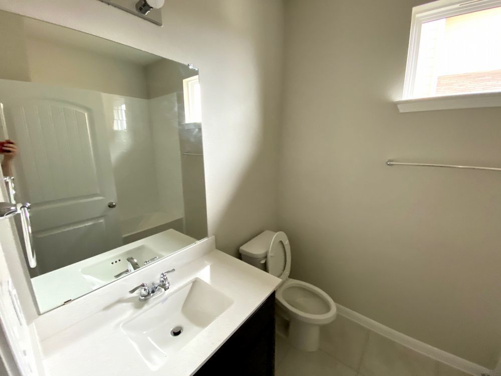 6713 Ranchito Drive Austin, TX 78744 - Photo 5 of 12 Bathroom with vanity, healthy amount of natural light, light tile patterned floors, and a shower