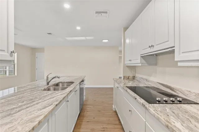 a kitchen with stainless steel appliances granite countertop a sink and cabinets