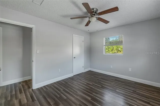 a view of empty room with wooden floor