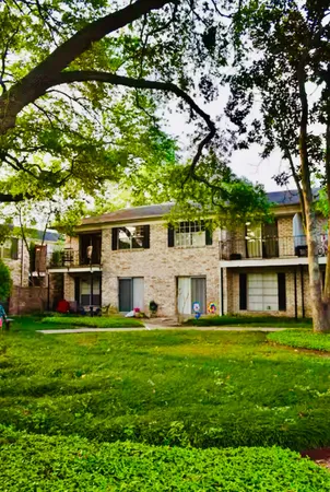 a view of a house with a big yard and large trees