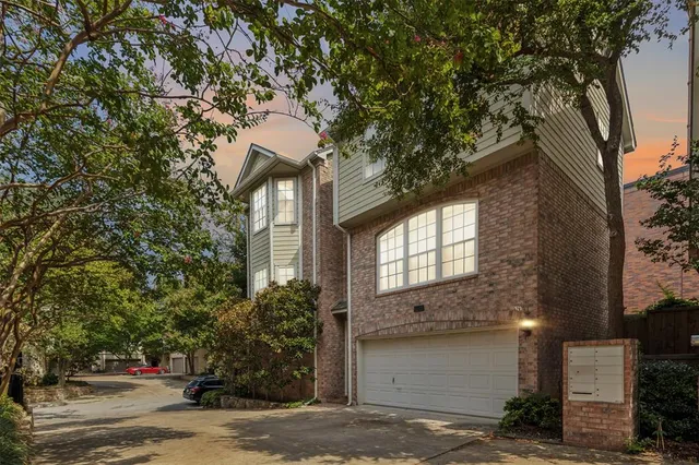 a front view of a house with a tree