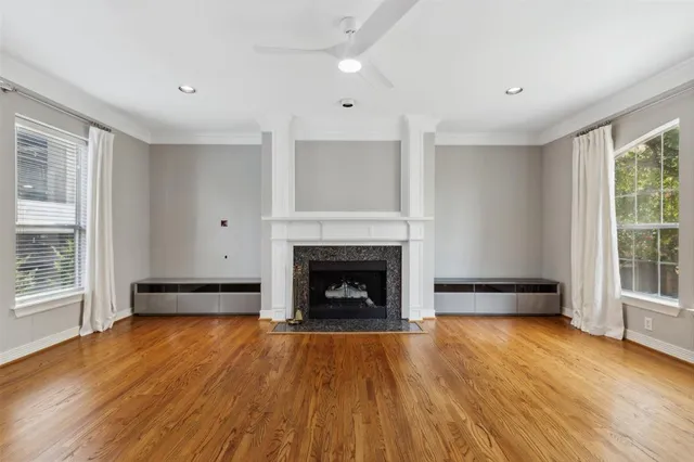 wooden floor fireplace and windows in an empty room