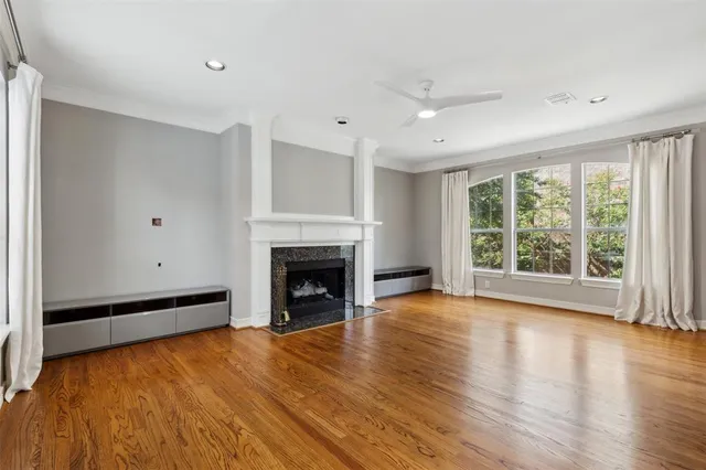 a view of empty room with wooden floor and fireplace