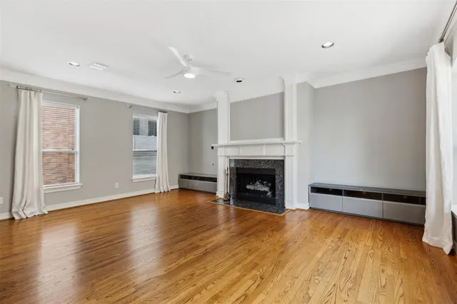 a view of empty room with wooden floor and fireplace