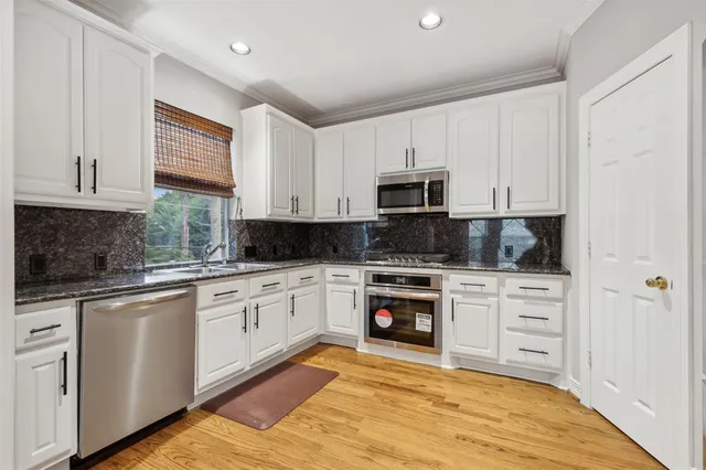 a kitchen with cabinets appliances and a window