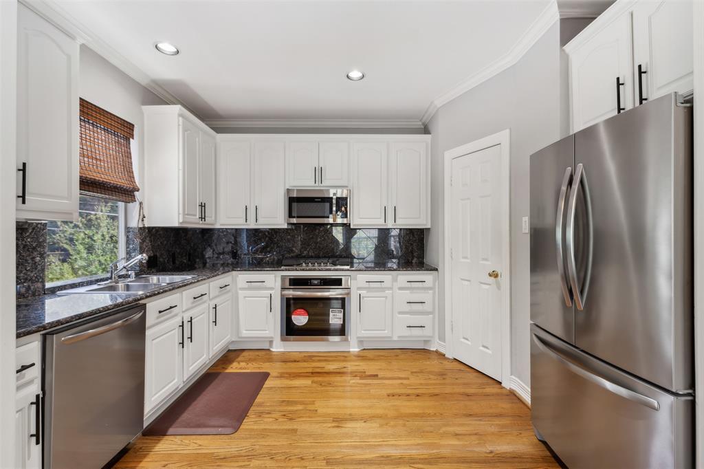 2704 Welborn Street, Unit H Dallas, TX 75219 - Photo 21 of 31 a kitchen with stainless steel appliances granite countertop a refrigerator sink and stove