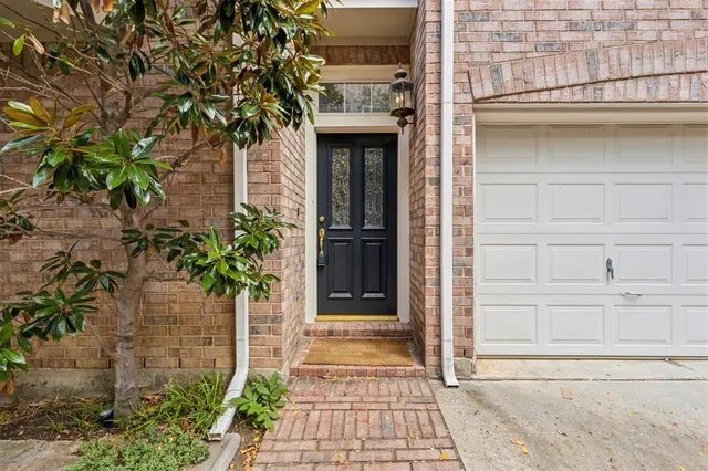a front view of a house with a door and potted plants