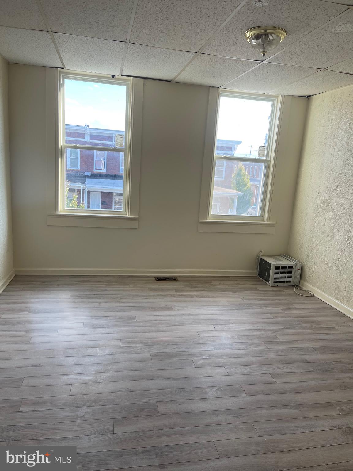 2926 East Madison Street Baltimore, MD 21205 - Photo 7 of 10 an empty room with wooden floor and windows