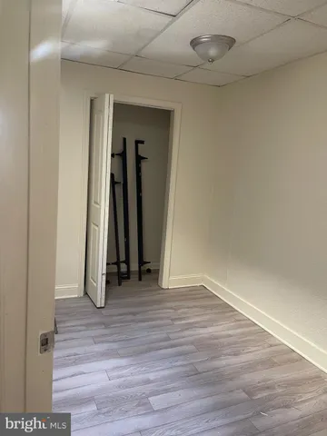 a view of a room with wooden floor and a ceiling fan