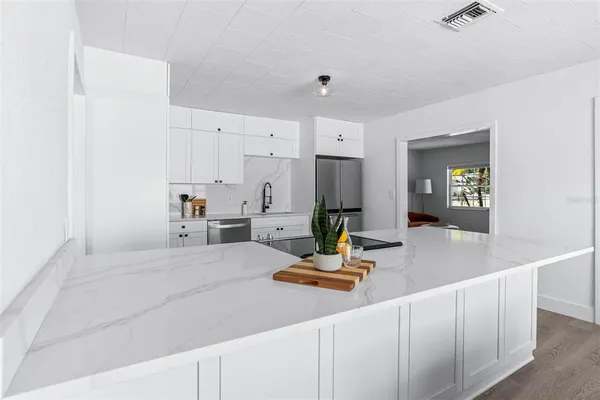 a bedroom with a bed a table and painting on the wall