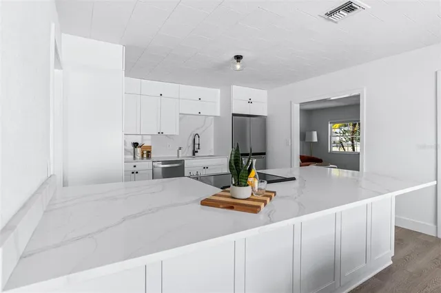 a bedroom with a bed a table and painting on the wall