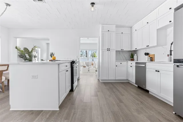 a kitchen with white cabinets and white appliances