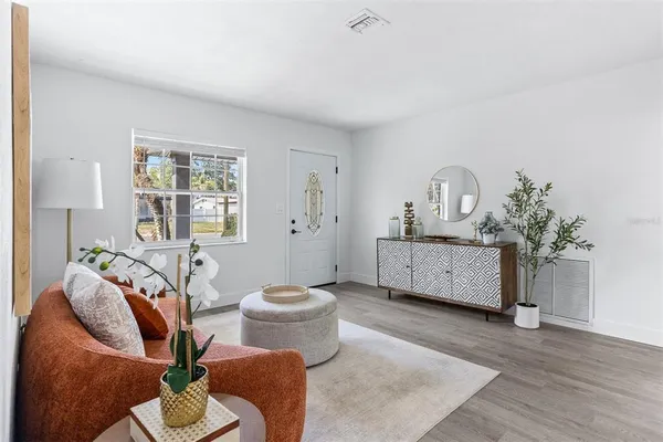 a living room with furniture a window and a potted plant
