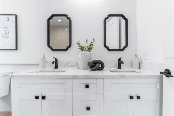 a bathroom with double vanity sinks and a mirror