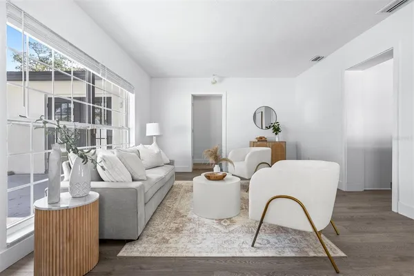 a living room with furniture a rug and white walls