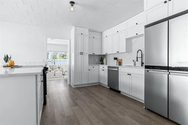 a kitchen with stainless steel appliances a refrigerator sink and cabinets