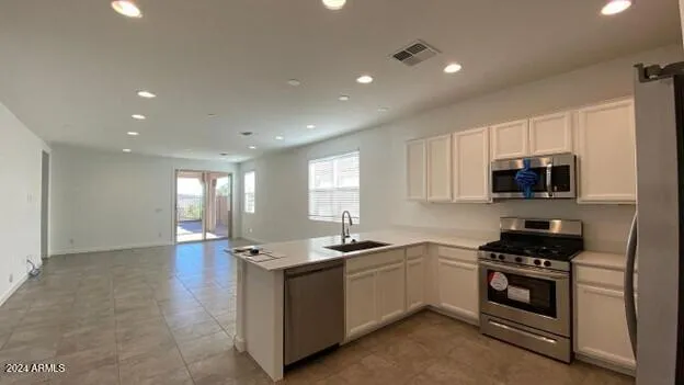 a kitchen with sink a microwave and cabinets