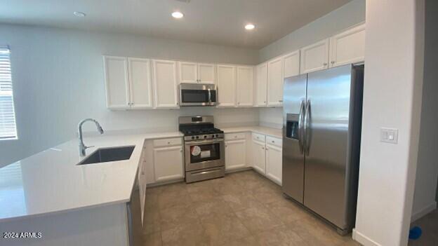31861 North 125th Lane Peoria, AZ 85383 - Photo 4 of 16 a kitchen with white cabinets and stainless steel appliances