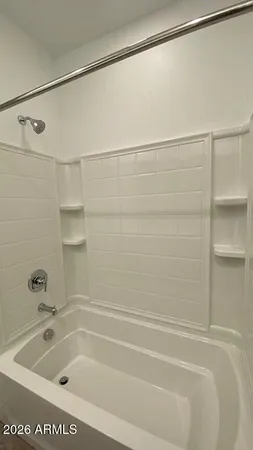 a bathroom with a tub shower and sink