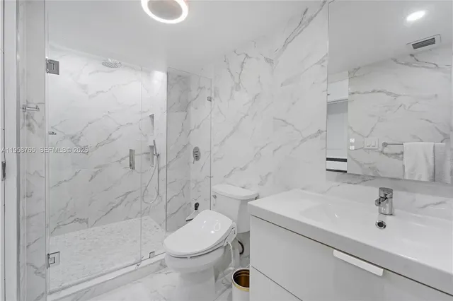 a bathroom with a sink a toilet and shower