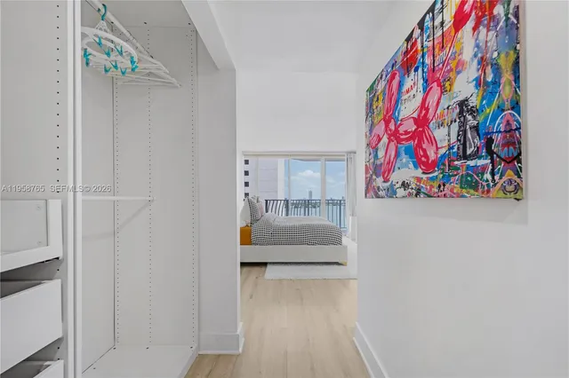 a hallway with painting on the wall and a potted plant