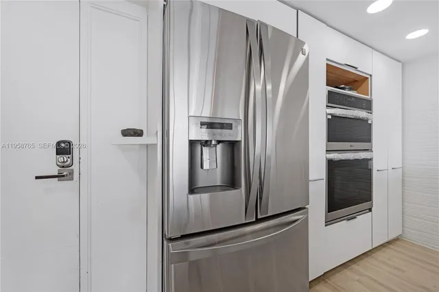 a metallic refrigerator freezer and a refrigerator in a kitchen