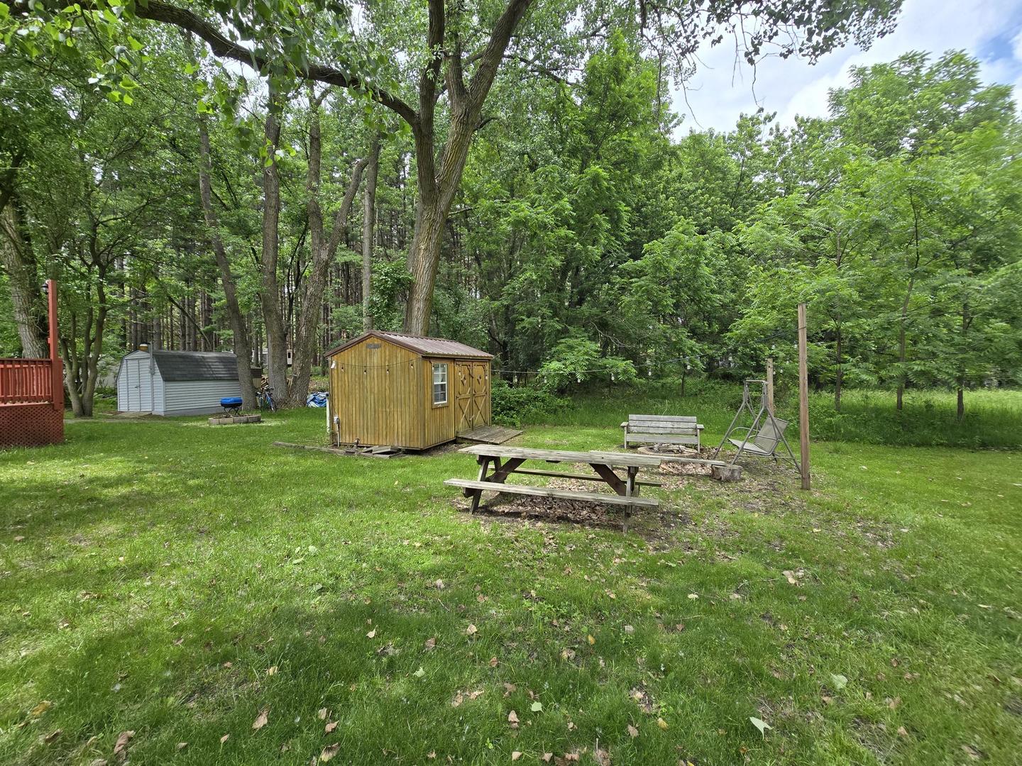 17-249 Woodhaven Sublette, IL 61367 - Photo 4 of 14 a backyard of a house with table and chairs a fire pit