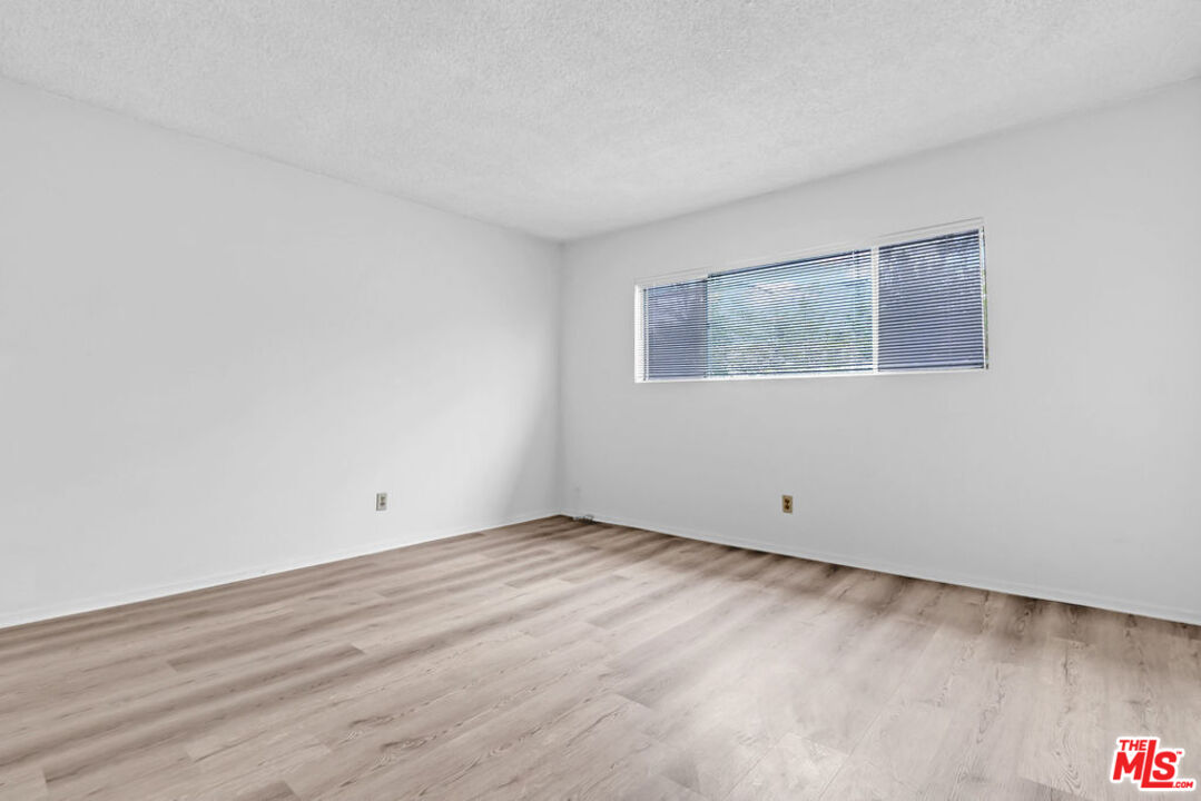 732 Lorraine Boulevard, Unit 5 Los Angeles, CA 90005 - Photo 15 of 25 a view of an empty room with wooden floor and a window